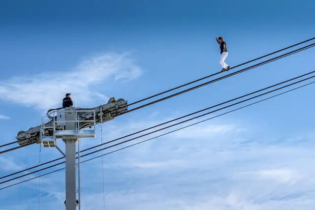 man in black t-shirt and black shorts on gray metal tower during daytime photo – Photo by Marc Wieland on Unsplash