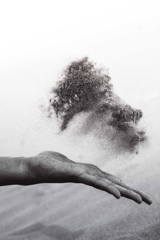 grayscaled photography of person's hand spreading sand photo – Photo by Kunj Parekh on Unsplash